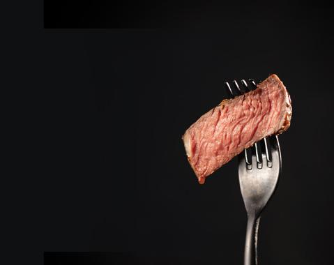 A slice of filet mignon steak on a fork.